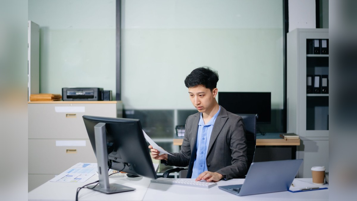 A student checking bank statements and admission documents at a desk before applying for a Georgian D3 student visa