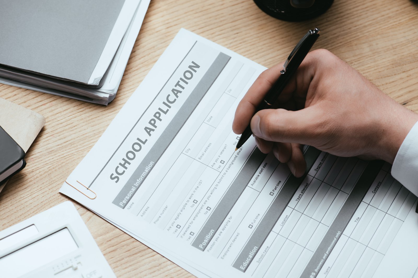 Hand filling in a scholarship application form — DSU Italy 2027