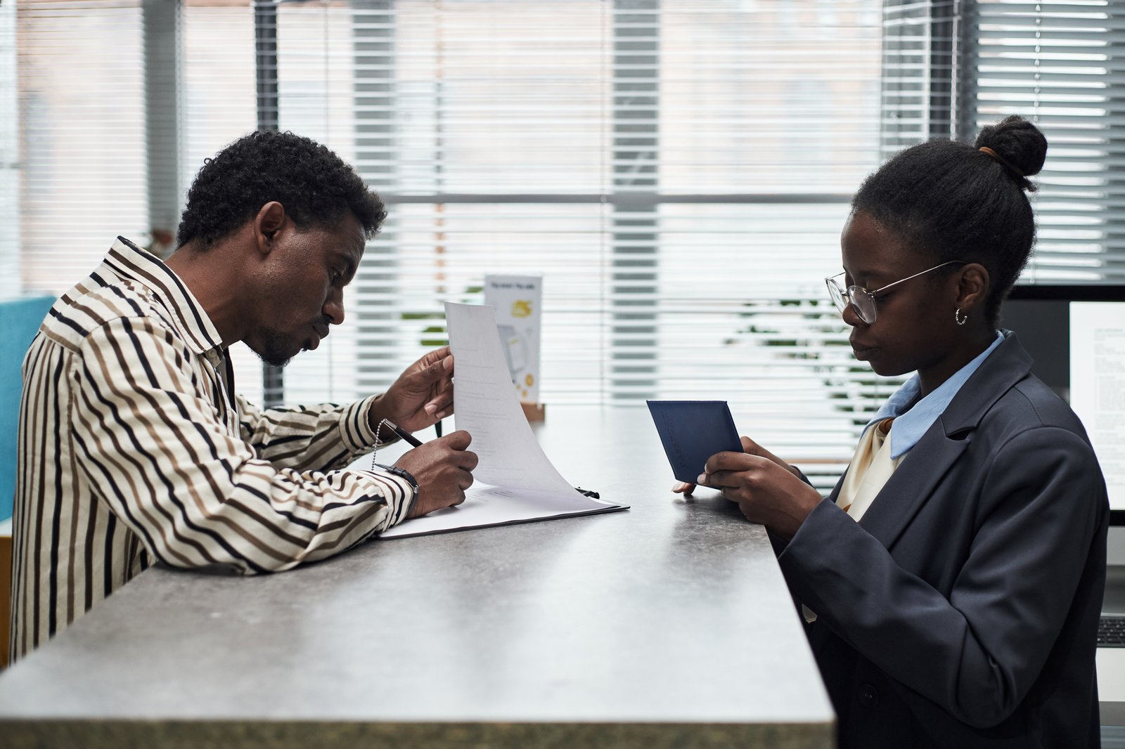 Student handing documents and passport across a counter while applying for a permesso di soggiorno in Italy 2027