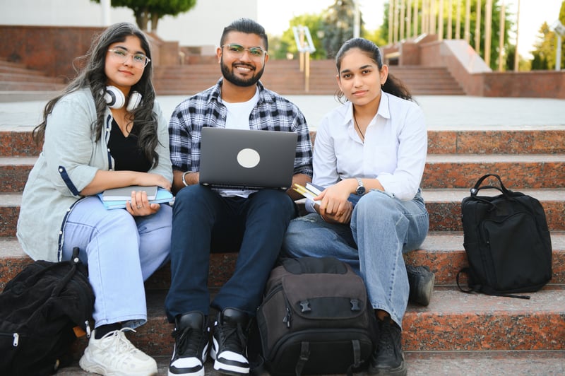 Bangladeshi students preparing Malaysia student visa documents together on campus steps