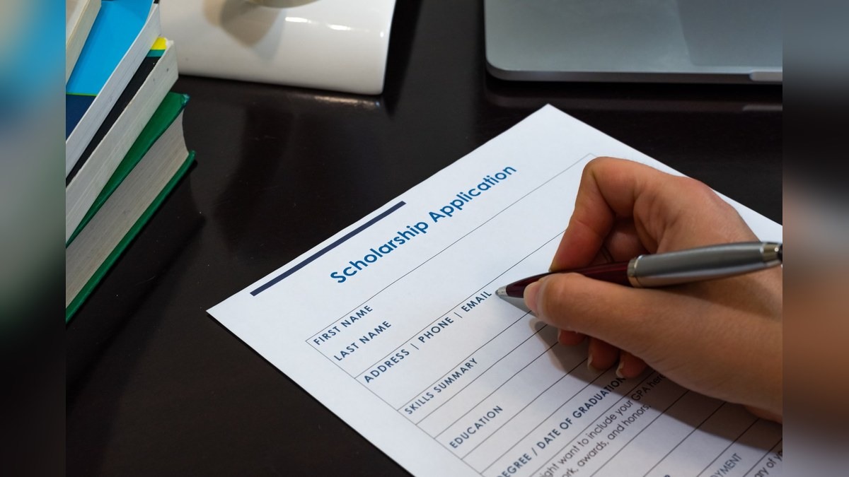 A student filling in a scholarship application form by hand for a Romanian government scholarship
