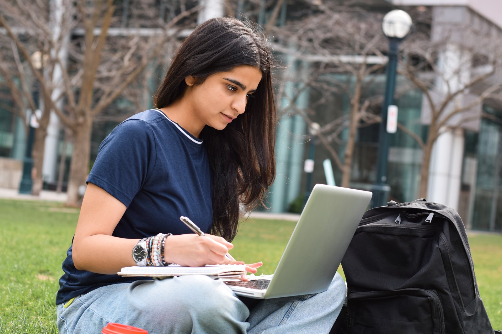 Bangladeshi student drafting an SOP for study abroad 2027 on a laptop and notebook on a university campus