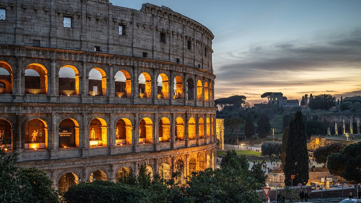 The Colosseum in Rome lit up at dusk, Italy